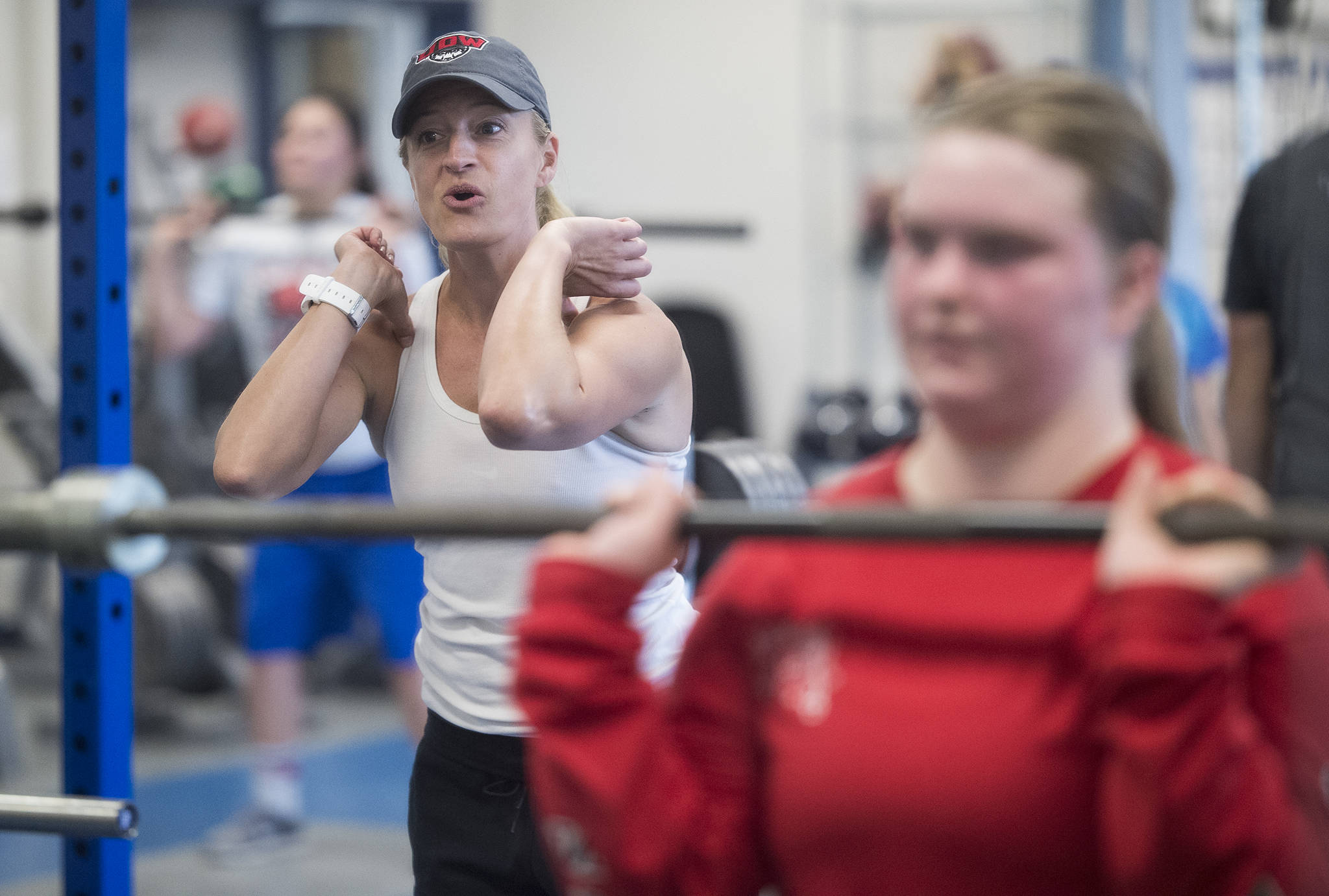 Cori Metzgar, Director of Sports Performance at Western Oregon University and host of the Juneau Football and Sports Performance Camp, gives Ariana Connally encouragement lifting weights at the Thunder Mountain High School last July. (Michael Penn | Juneau Empire File)