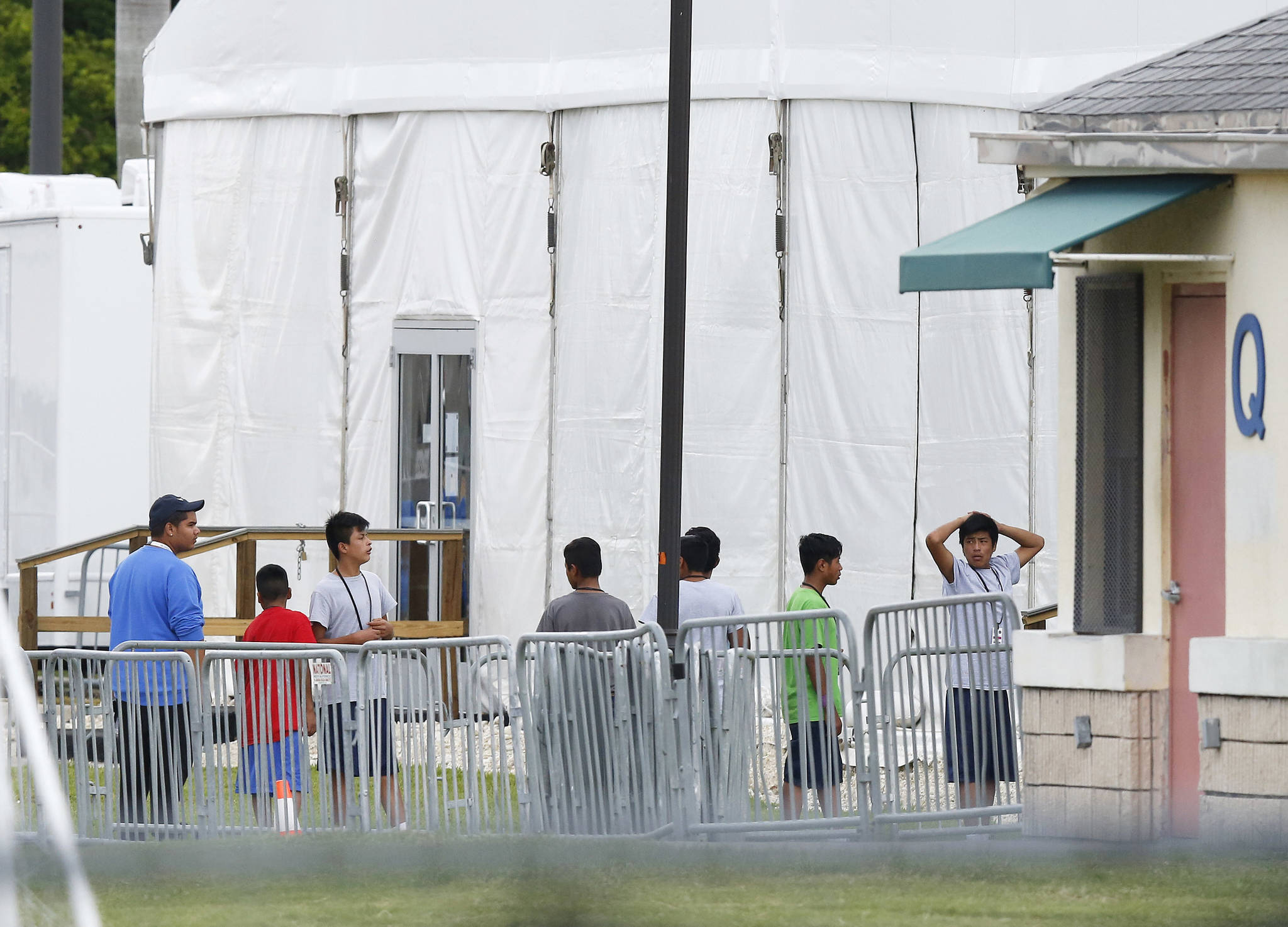Immigrant children walk in a line outside the Homestead Temporary Shelter for Unaccompanied Children, a former Job Corps site that now houses them, on Wednesday, June 20, 2018, in Homestead, Florida. U.S. Rep. Carlos Curbelo said he found it troubling to see two of his Democratic colleagues turned away from the Miami-area detention center for migrant children. (Brynn Anderson | The Associated Press)