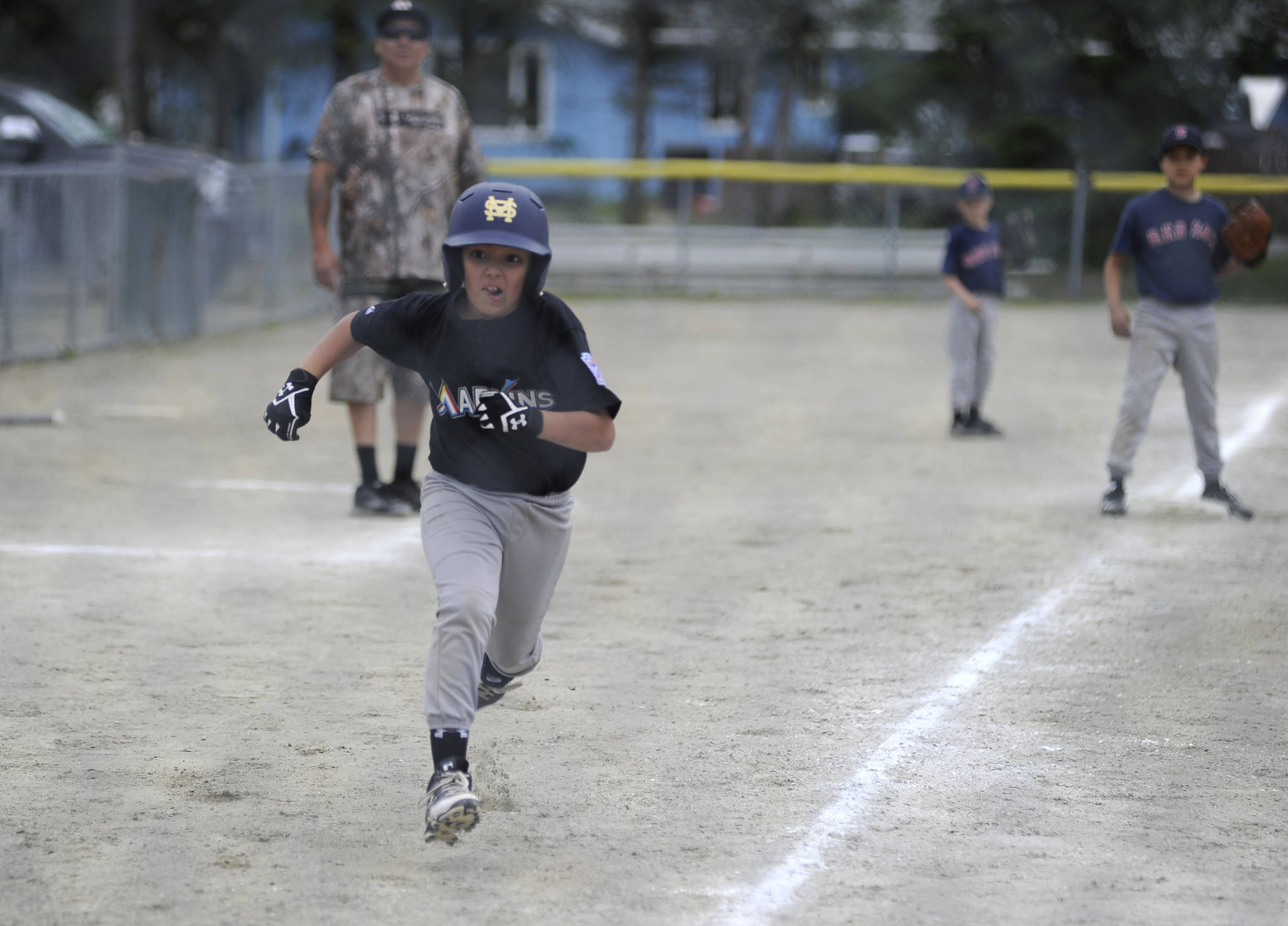 Marlins player Nilsen Nelson watches the ball as he comes home to score in the Gastineau Channel Little League Minor Division Championship game on Saturday at Miller Field. (Nolin Ainsworth | Juneau Empire)