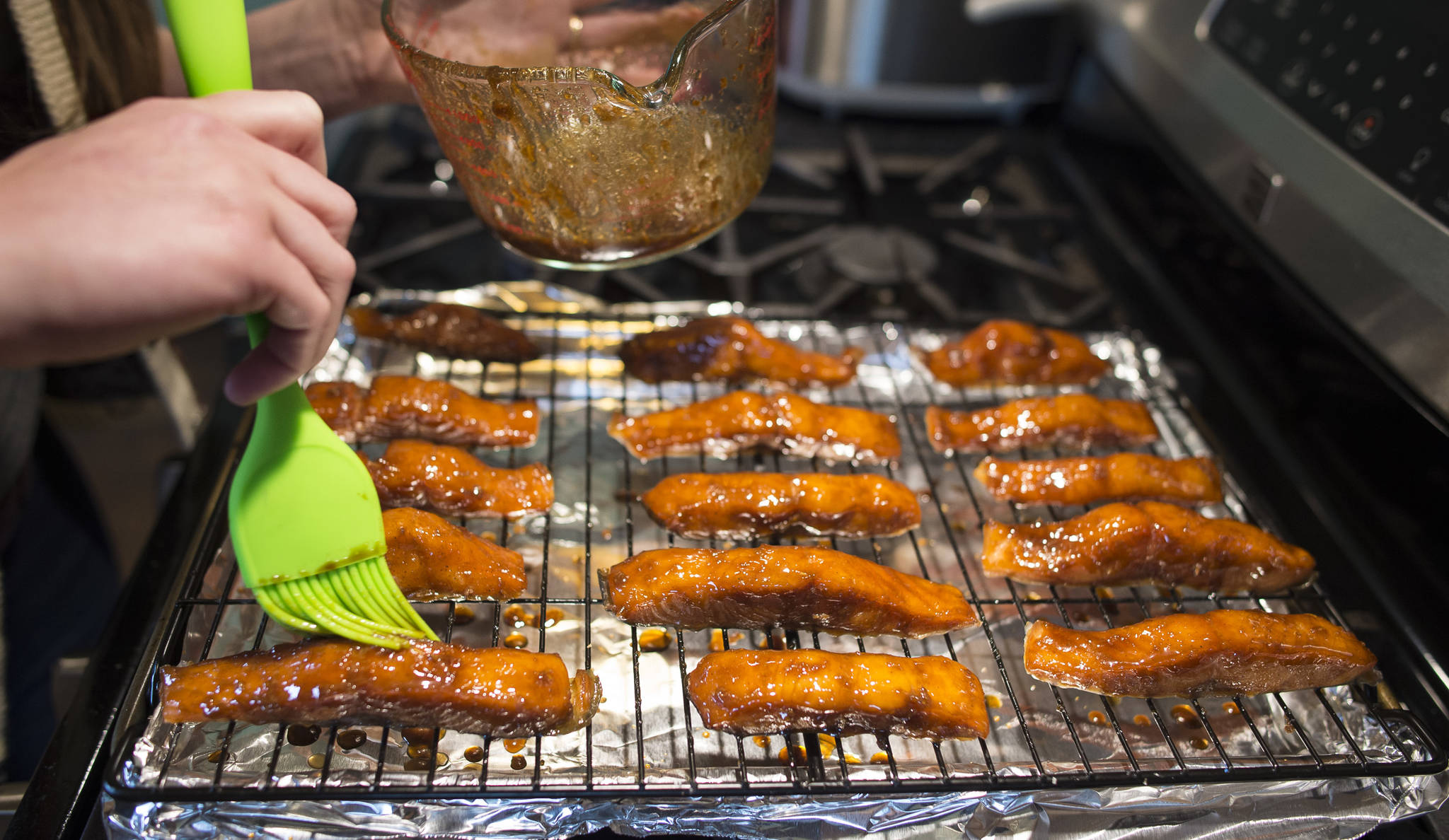 Erin Anais Heist prepares candied chum salmon at her home kitchen on Wednesday, June 27, 2018. (Michael Penn | Juneau Empire)