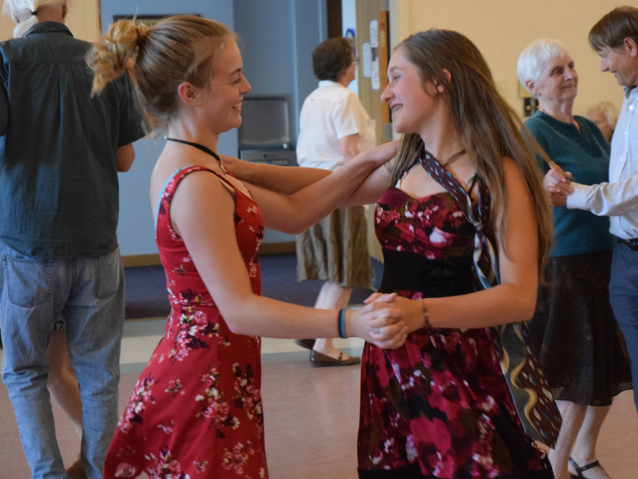Ellie Knapp and Adelie McMillan dance together at the annual pre-fireworks “Barn Dance” at St. Ann’s Parish Hall Tueday, July 3. (Gregory Philson | Juneau Empire)