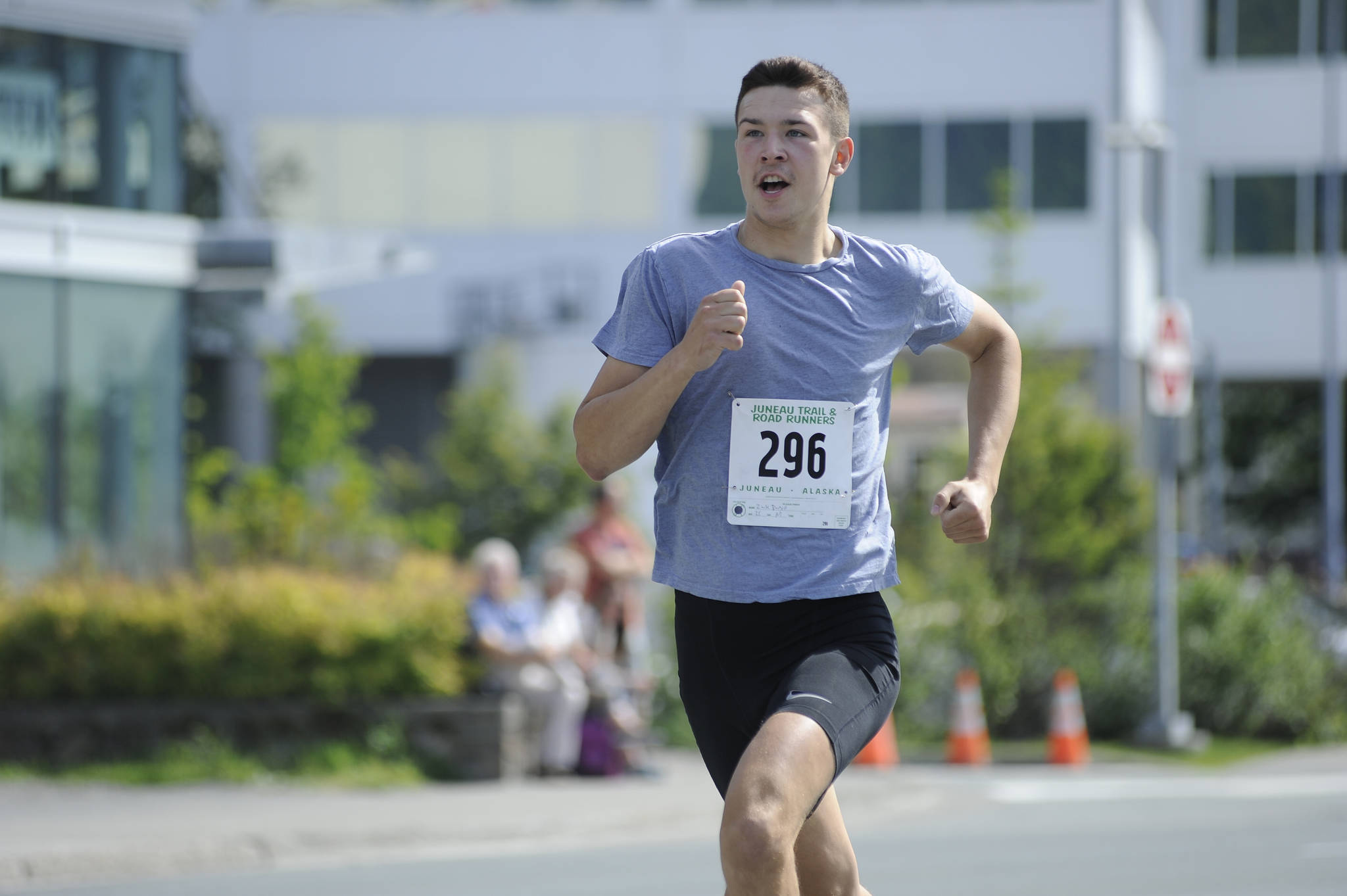 Zach Bursell sprints to the finish line of the Glenn Frick Memorial Mile, which took place just before the start of the Juneau Fourth of July Parade on Wednesday morning. Bursell placed first overall and set a new course record in the mile. (Nolin Ainsworth | Juneau Empire)