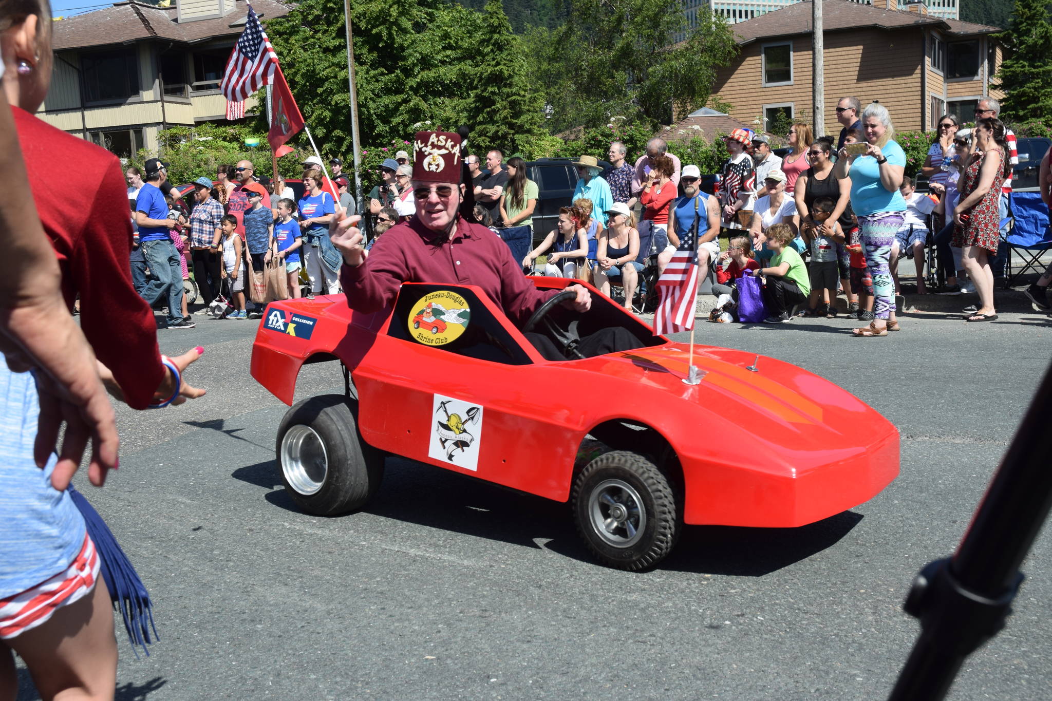 A member of the Juneau-Douglas Shrine Club waves a flag in the Douglas Fourth of July parade on Wednesday. (Kevin Gullufsen | Juneau Empire)