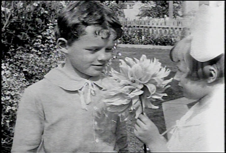 A still from “A Day in Skagway,” the Burton Holmes travelogue produced for Paramount Pictures in 1918. This scene is of a boy and girl (Kenneth Blanchard and Evelyn Curtin) sharing a large dahlia in one of Skagway’s beautiful gardens. Photo courtesy of Human Studies Film Archives, Smithsonian Institution; the American Film Institute and the National Film and Sound Archives, Australia.