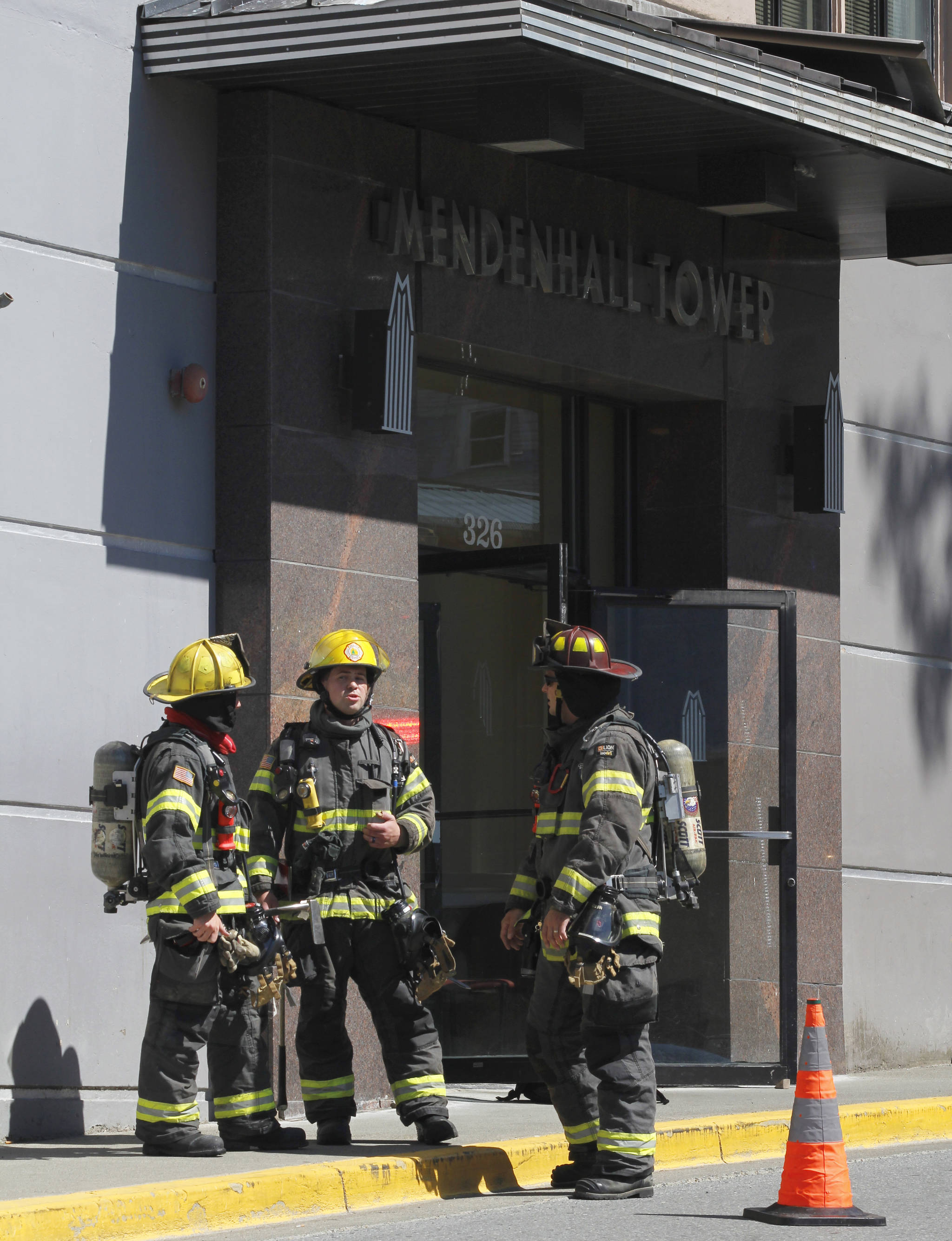Firefighters prepare to enter the Mendenhall Tower Apartments on Thursday, July 5, 2018 to respond to a kitchen fire on the third floor. (Alex McCarthy | Juneau Empire)