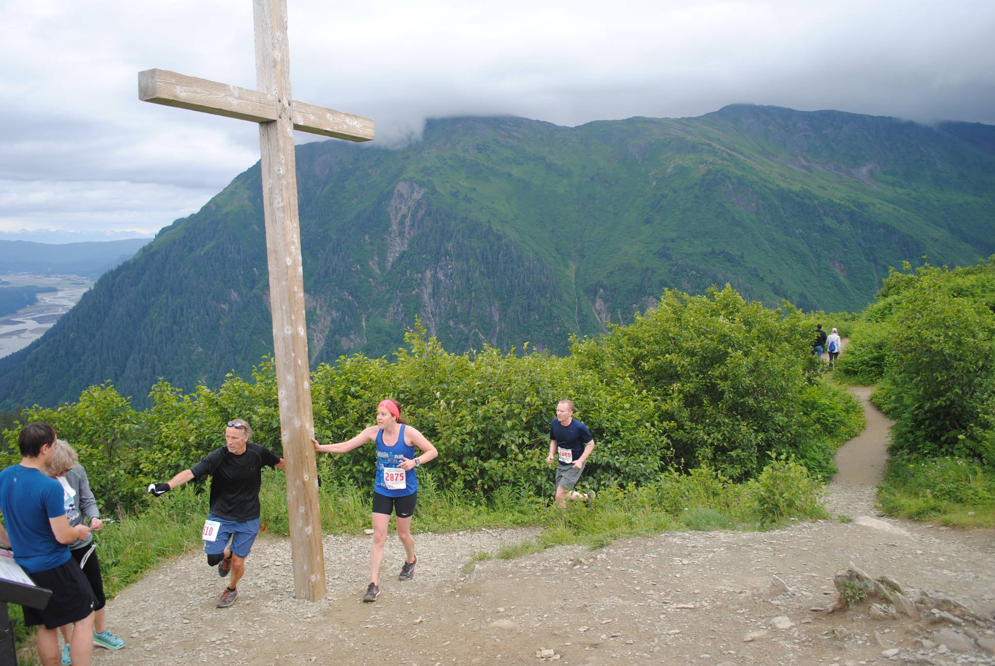 Runners touch the Father Brown’s cross, which served as the finish line at the Mt. Roberts Tram race on Saturday morning. (Photo courtesy Darla Orbistondo)