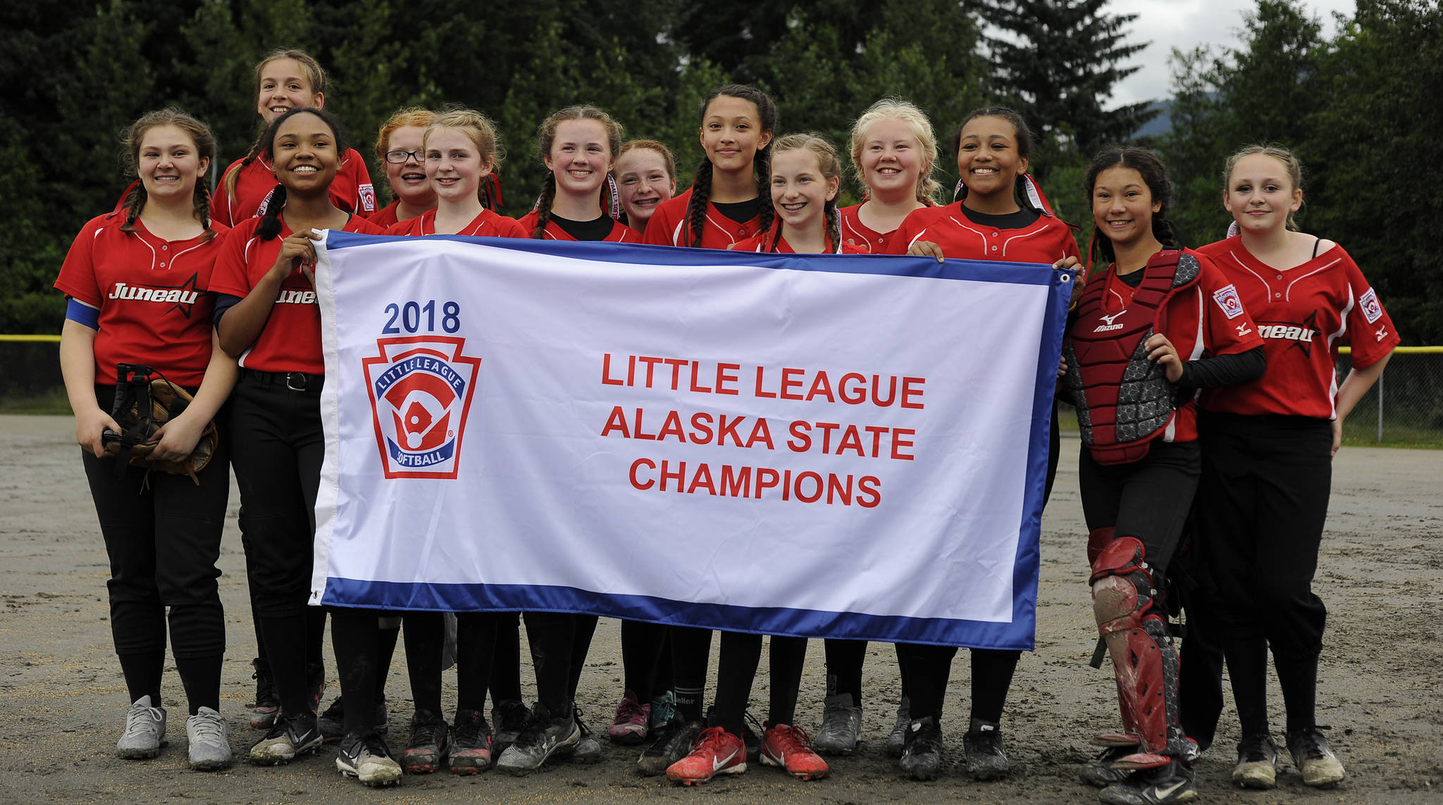The Gastineau Channel Little League Major Softball all-stars pose with the state championship banner after defeating Anchorage’s Abbott-O-Rabbit, 7-5, to win the state championship on Saturday at Melvin Park. (Nolin Ainsworth | Juneau Empire)