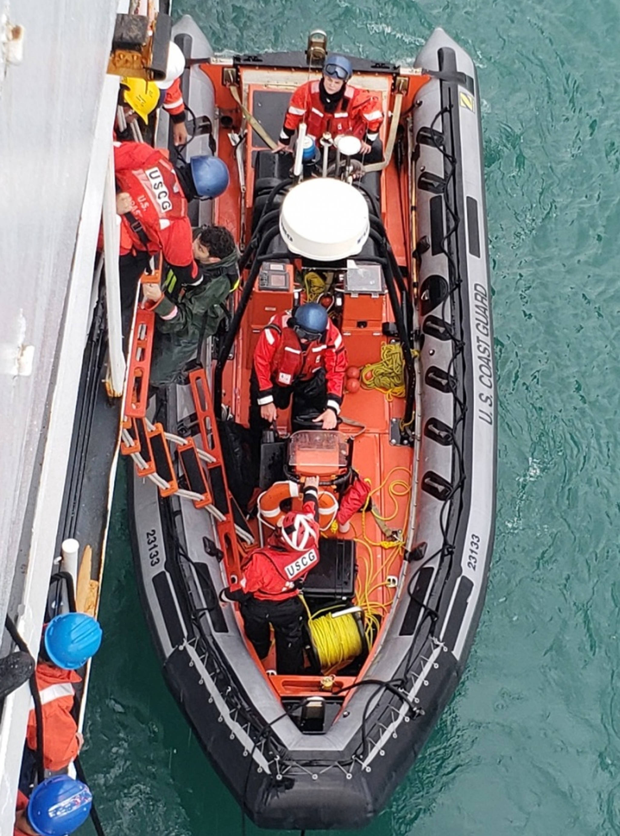 Coast Guard Cutter Douglas Munro crew members assist a survivor off a Coast Guard small boat in Glacier Bay National Park, July 15, 2018. Rough waters overturned four kayaks in Glacier Bay National Park, but the individuals made it to shore and activated their personal locator beacon, which assisted the Coast Guard in locating them. (U.S. Coast Guard | Courtesy Photo)