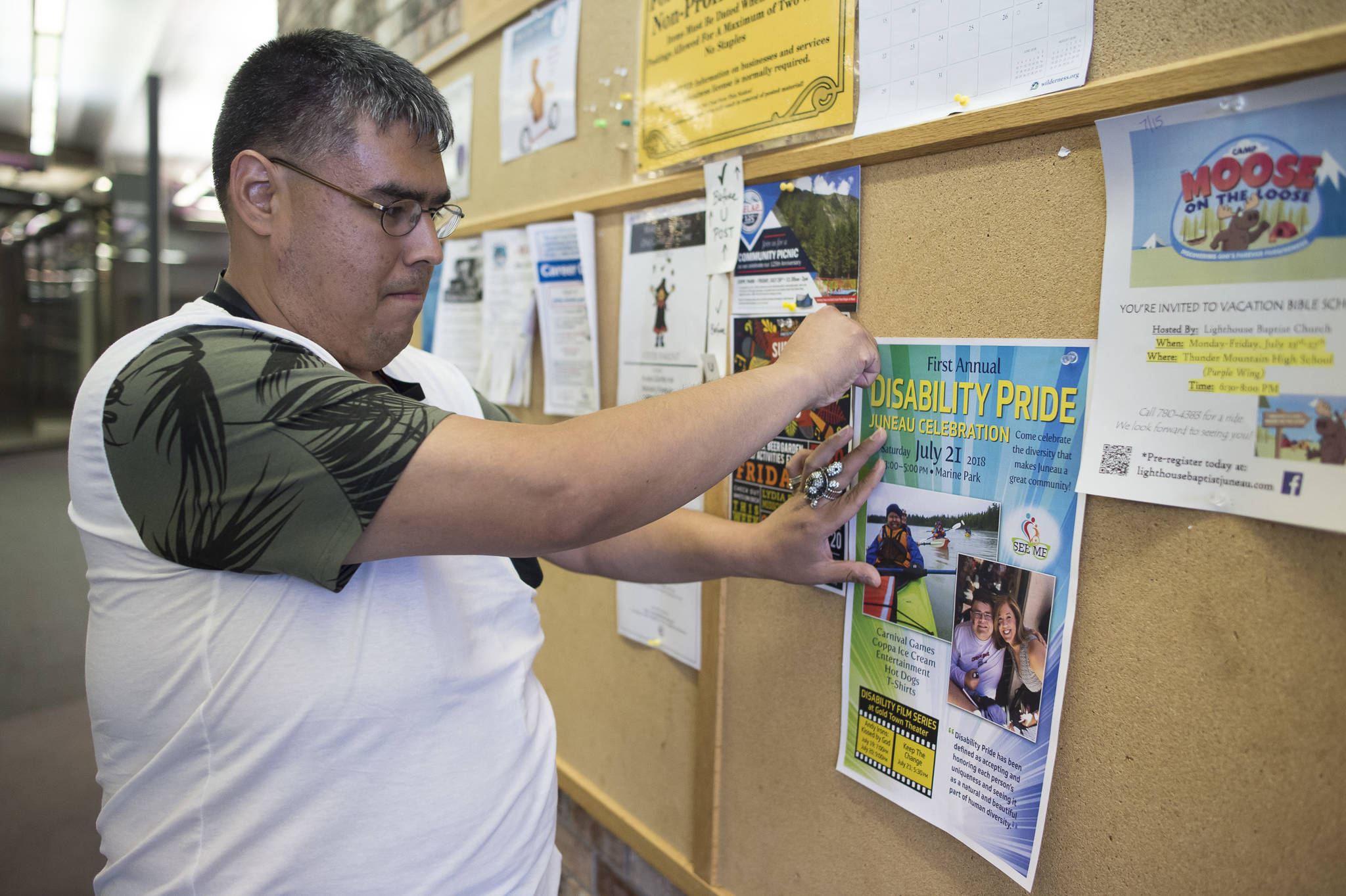 Luis Hernandez hangs posters at the Mendenhall Mall advertising this weekend’s Disability Pride Celebration. The celebration is Saturday, July 21, from 3 to 5 p.m. at Marine Park. (Michael Penn | Juneau Empire)