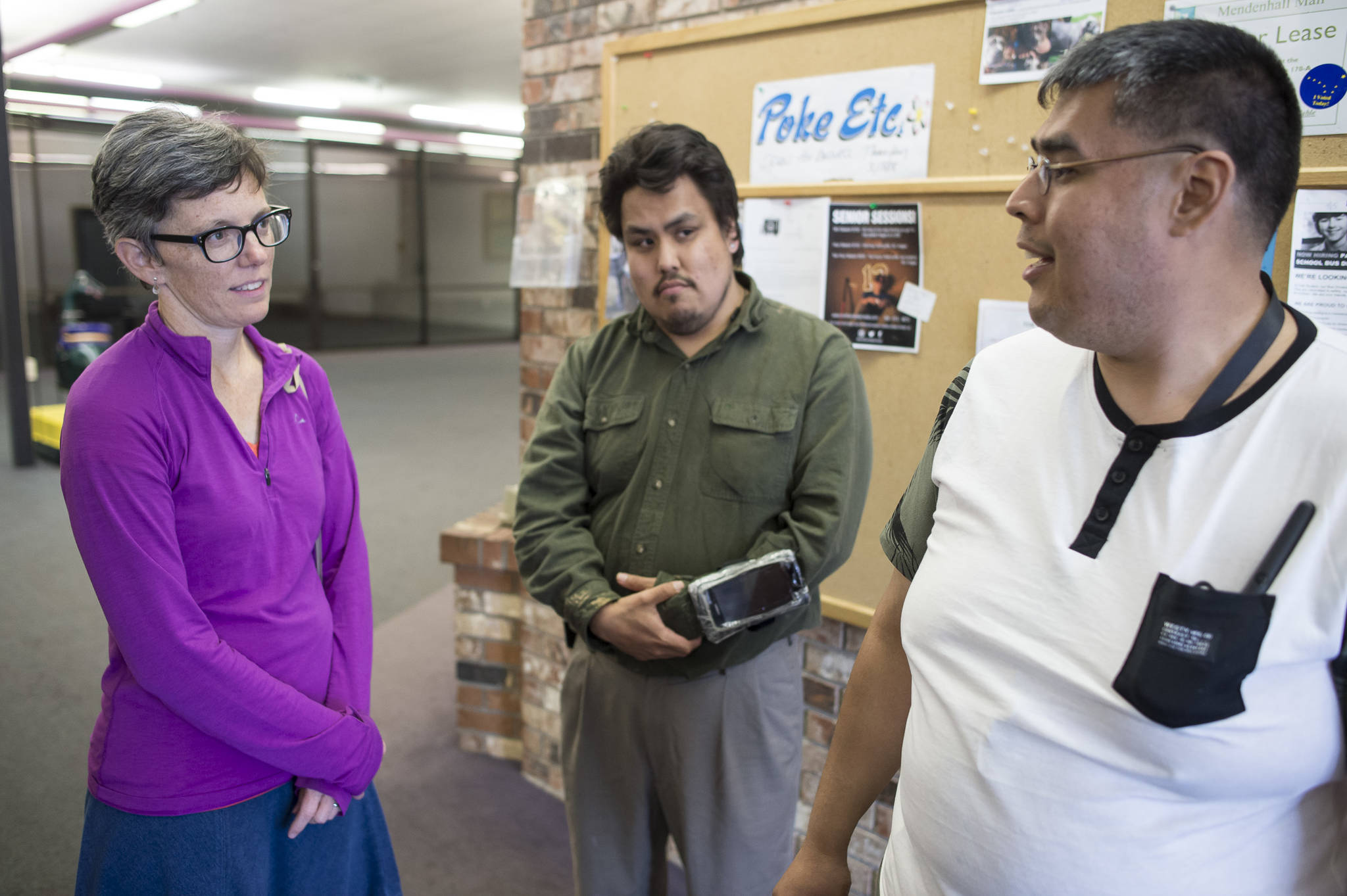 Kim Champney, a disability advocate, meets with Melvin Starr, center, and Luis Hernandez to hang posters at the Mendenhall Mall advertising this weekend’s Disability Pride Celebration. The celebration is Saturday, July 21, from 3 to 5 p.m. at Marine Park. (Michael Penn | Juneau Empire)