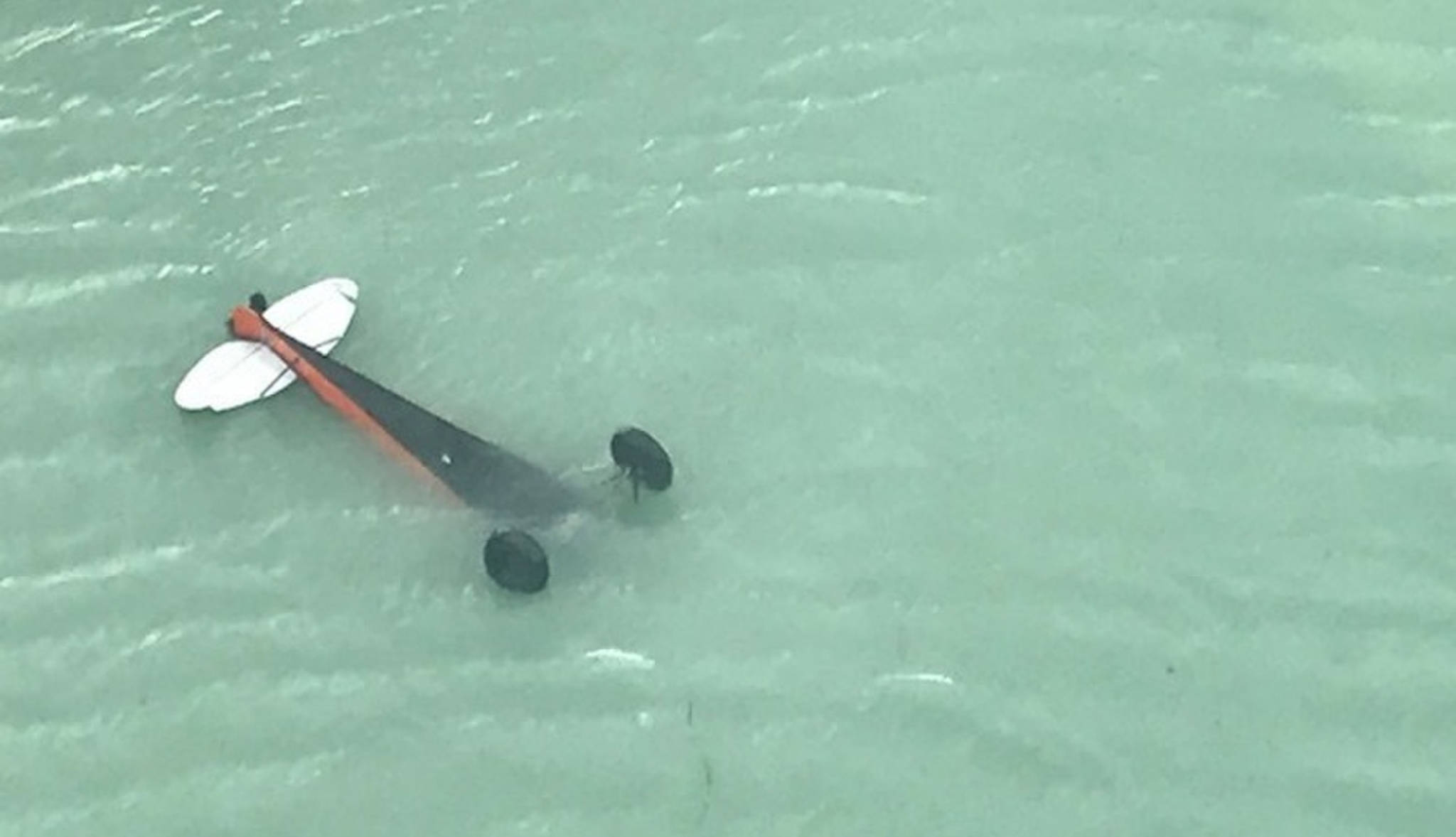 A Coast Guard Air Station Sitka MH-60 Jayhawk helicopter aircew locates a downed aircraft inverted in Crillon Lake, in Glacier Bay National Park, Alaska, July 18, 2018. The National Park Service requested Coast Guard assistance in locating the pilot of the aircraft, who was found and hoisted from a Crillon Lake shore with minor injuries. (U.S. Coast Guard | Courtesy Photo)