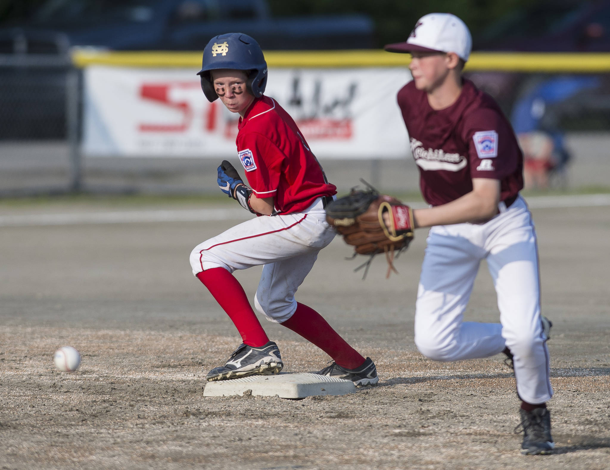 Gastineau Channel’s Kean Buss, left, steals second against Ketchikan’s shortstop Colton Shull in the third inning of the Alaska Major Baseball District 2 Championship Game at Miller Field on Tuesday. (Michael Penn | Juneau Empire)