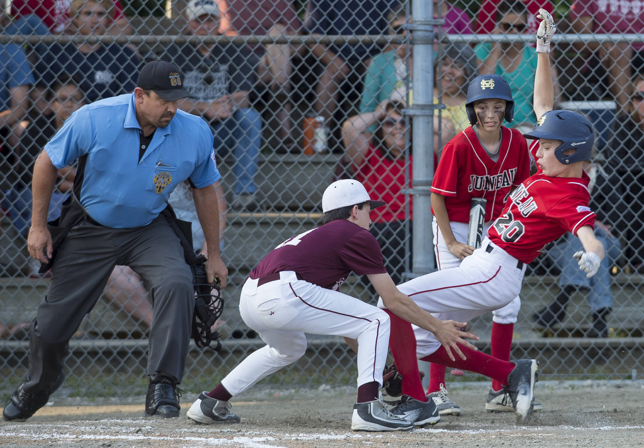 Gastineau Channel’s Kaleb Campbell is caught trying to steal home by Ketchikan’s Colby Hanchey in the fourth inning of the Alaska Major Baseball District 2 Championship Game at Miller Field on Tuesday. (Michael Penn | Juneau Empire)