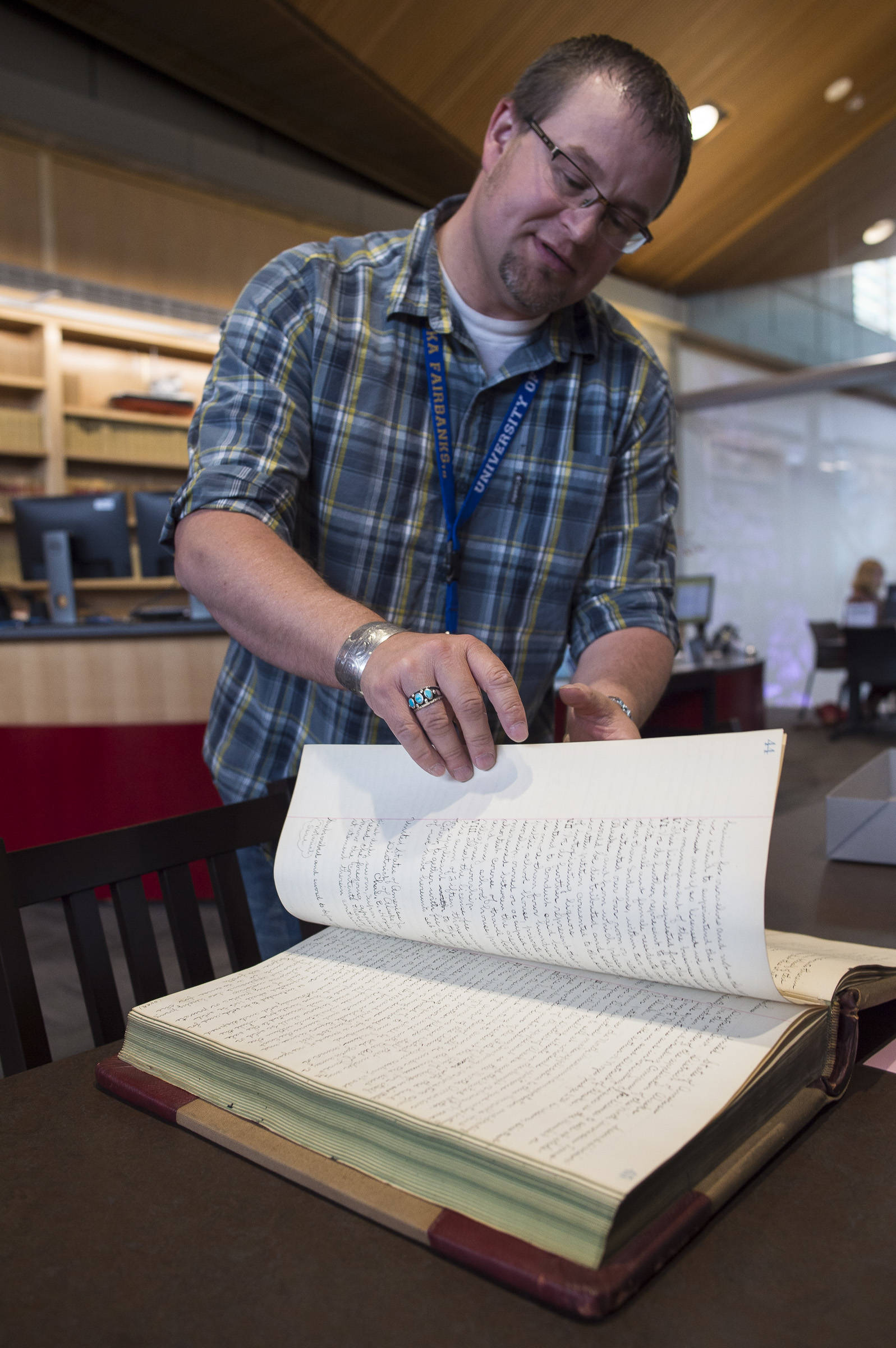 Archivist Zach Jones looks for Wyatt Earp’s July 1900 application for a Nome liquour at the Alaska State Archives on Friday, July 27, 2018. (Michael Penn | Juneau Empire)