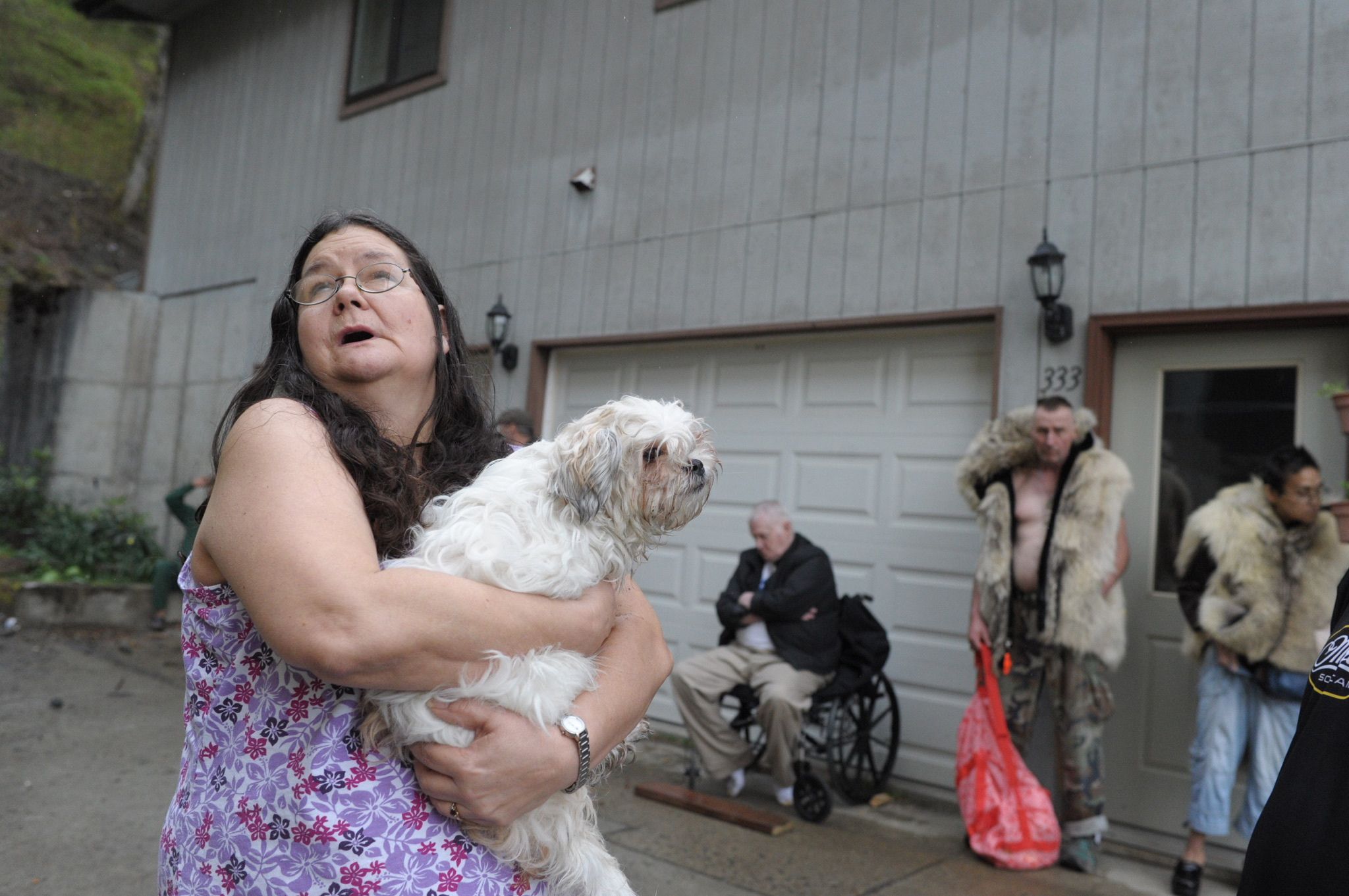 Hazel LeCount holds her pet dog, Serenity, as she waits with other residents to be let back into the Channel View Apartments on Sunday after a fire broke out in a unit on the fifth floor.