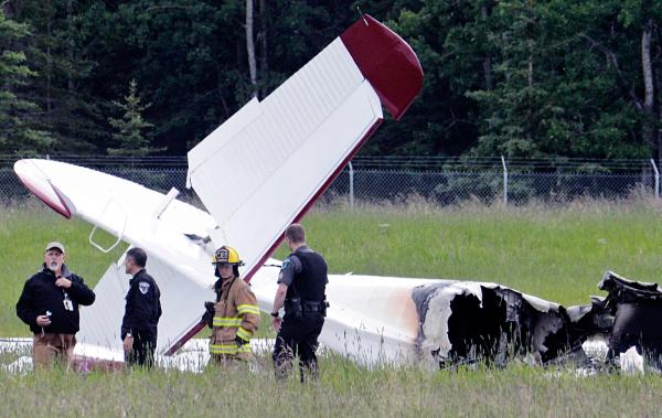 Police and emergency personnel stood near the remains of a fixed-wing aircraft at the Soldotna Airport in Soldotna.