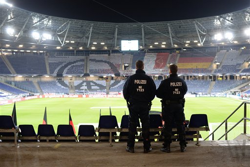 Two police officers stand in the HDI-Arena in Hannover, Germany, Tuesday, Nov. 17, 2015 just before the stadium was evacuated before the friendly soccer match between Germany and the Netherlands.