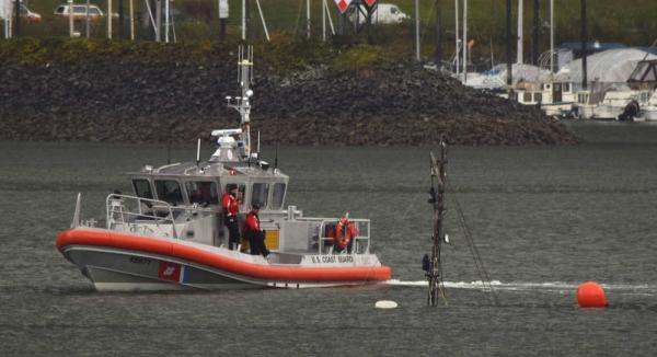A U.S. Coast Guard Station Juneau small-boat crew examines the mast of the sunken 94-foot tugboat Challenger on Saturday afternoon, Sept. 12, 2015 in Gastineau Channel. The crew marked the wreck with a buoy and a flashing light installed on the mast.