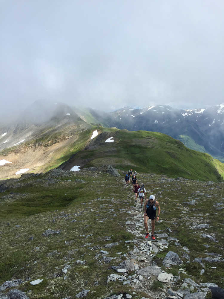 A group of runners make their way along a highly technical section of the Juneau Ridge.