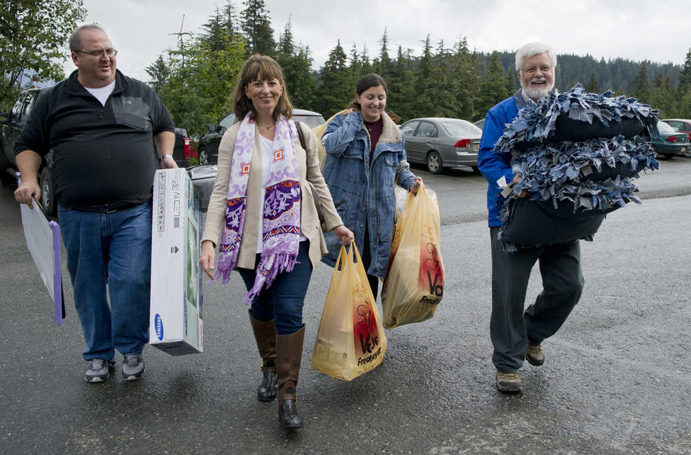 Dan and Lisa Galloway gets help from Chancellor John Pugh, right, as they move their daughter, Catherine, into the new freshman student housing at the University of Alaska Southeast in August 2014. The resident housing has been named after Pugh, who retired at the end of the last school year.