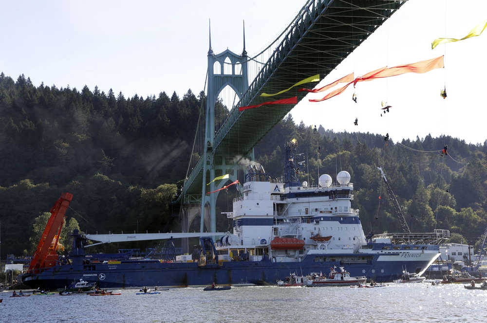 File - In this July 25, 2015 file photo, the Royal Dutch Shell PLC icebreaker Fennica heads up the Willamette River under protesters hanging from the St. Johns Bridge on its way to Alaska in Portland, Ore.