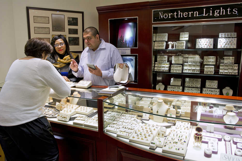 Kris Chhabria, owner of Jewels by Kris, works with employee Joyce Warner on making a sale at his South Franklin Street jewelery store in August.