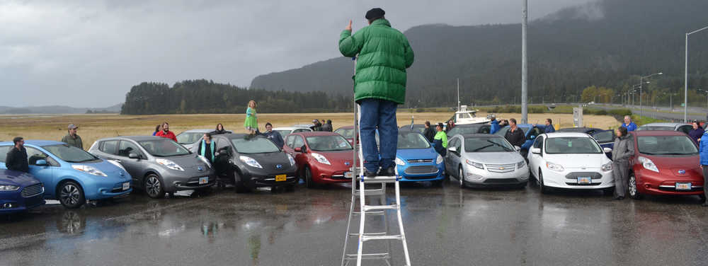 Juneau panoramic photographer Ron Klein stands on a ladder to take a picture of 24 Juneau electric cars assembled at the Mendenhall Wetlands to celebrate national Drive Electric Week.  The assembly was one of 196 events held across the country to encourage more Americans to consider electric cars.