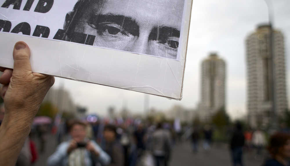 A protester holds a poster with portrait of Russian President Vladimir Putin during an opposition rally Sunday in Moscow, Russia.