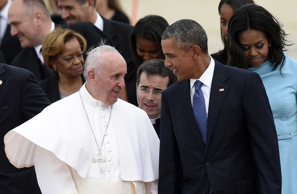 Pope Francis talks with President Barack Obama after arriving at Andrews Air Force Base in Md., Tuesday, Sept. 22, 2015. The Pope is spending three days in Washington before heading to New York and Philadelphia. This is the Pope's first visit to the United States. First lady Michelle Obama is at right. (AP Photo/Susan Walsh)