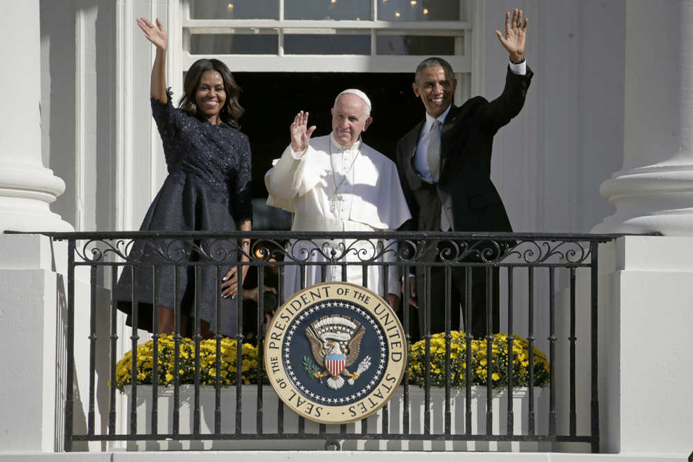 President Barack Obama, first lady Michelle Obama and Pope Francis wave to the crowd on the South Lawn from the Truman Balcony of the White House Wednesday in Washington.