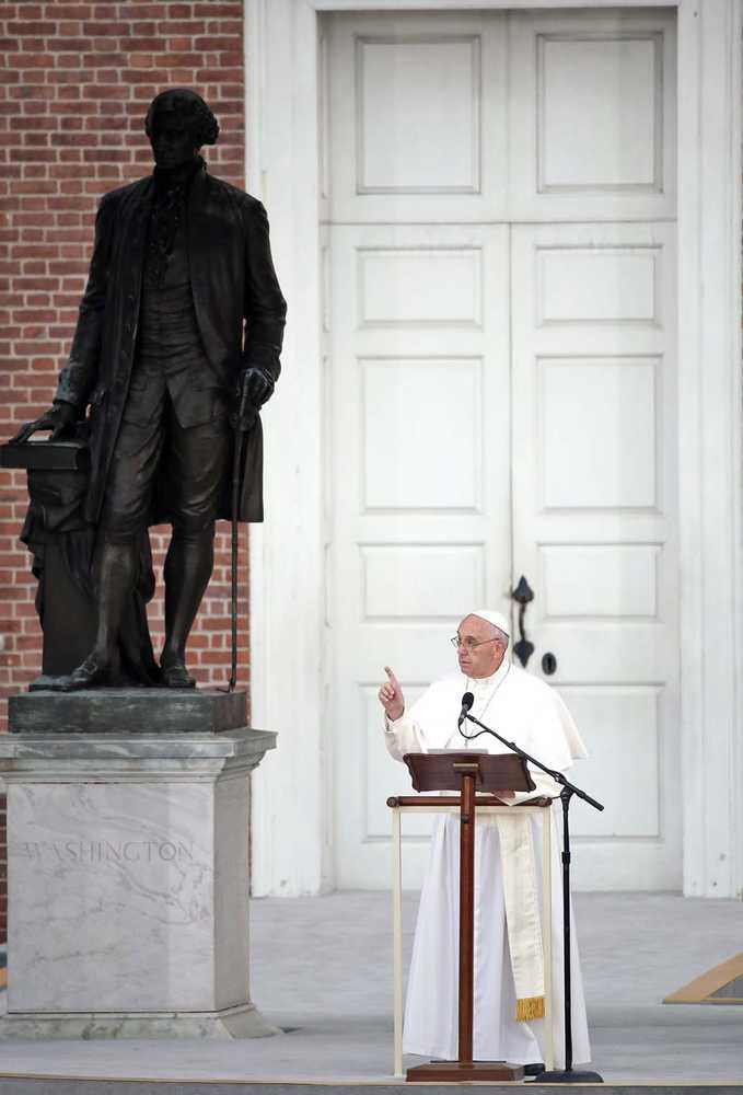 Pope Francis speaks in front of Independence Hall from the lectern used by President Abraham Lincoln during the Gettysburg Address alongside a statue of President George Washington on Saturday in Philadelphia.