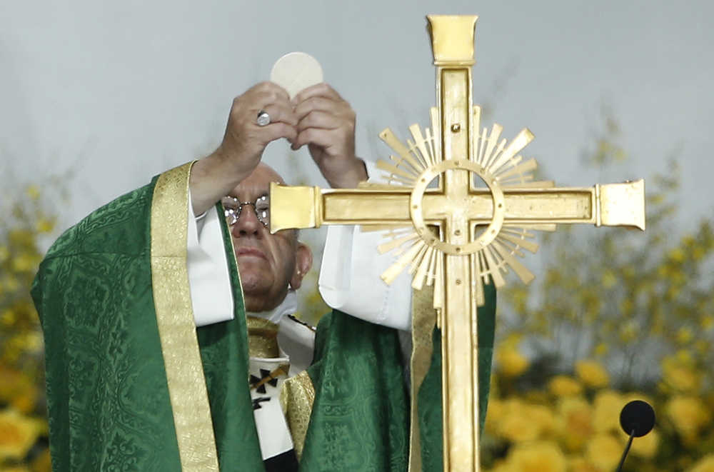 Pope Francis blesses the bread while preparing communion during Mass Sunday in Philadelphia.