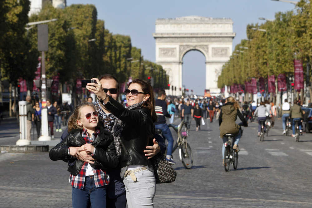 A familiy takes a selfie on the Champs Elysees during the "day without cars" on Sunday in Paris, France.