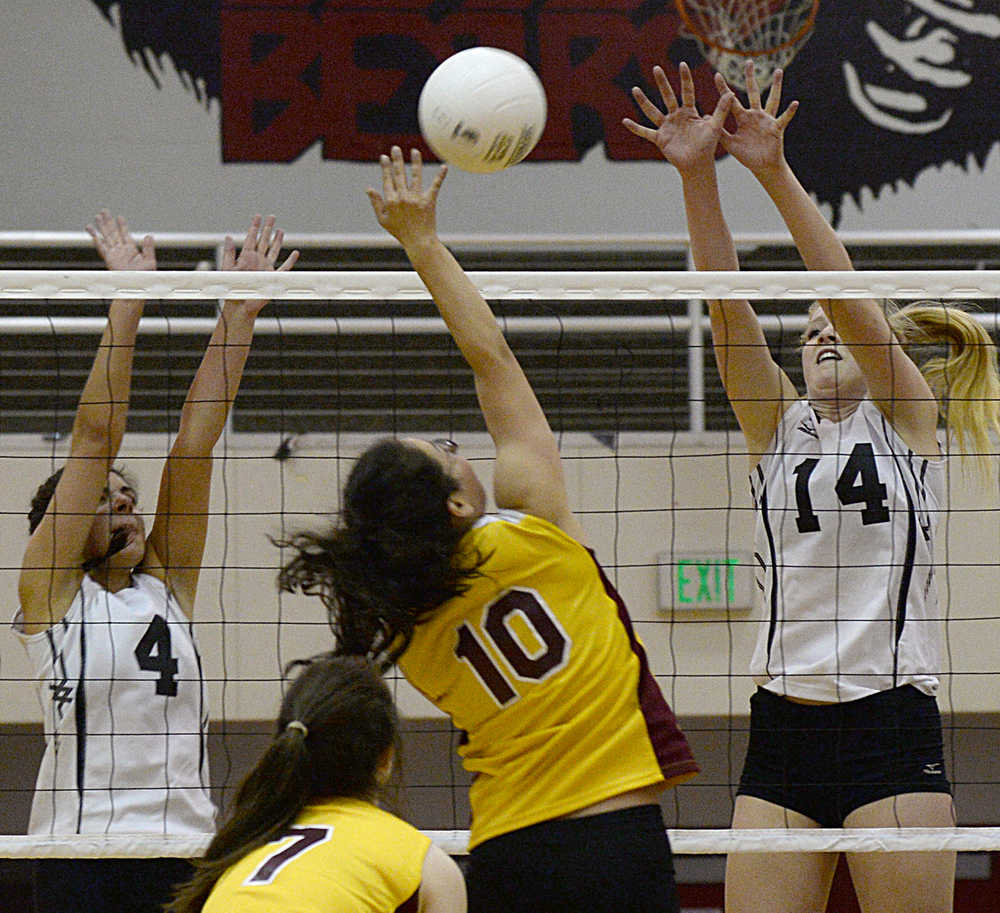 Juneau-Douglas' Leah Spargo (4) and Maddie McKeown (14) defend a spike by Mt. Edgecumbe's Roselyn Lowe (10) during high school volleyball action this season.