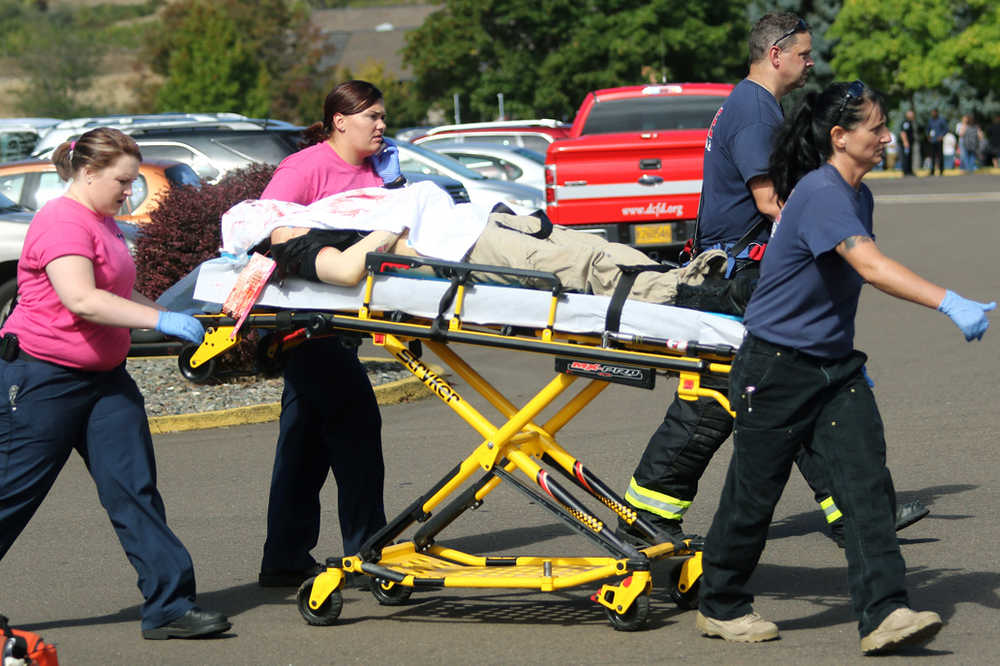 Authorities carry a shooting victim away from the scene after a gunman opened fire at Umpqua Community College on Thursday in Roseburg, Oregon.