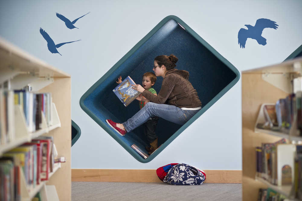 Jessica Walsh reads to her son, Silas, 3, in a carpeted nook on the first day of the new Mendenhall Valley Public Library on Monday.