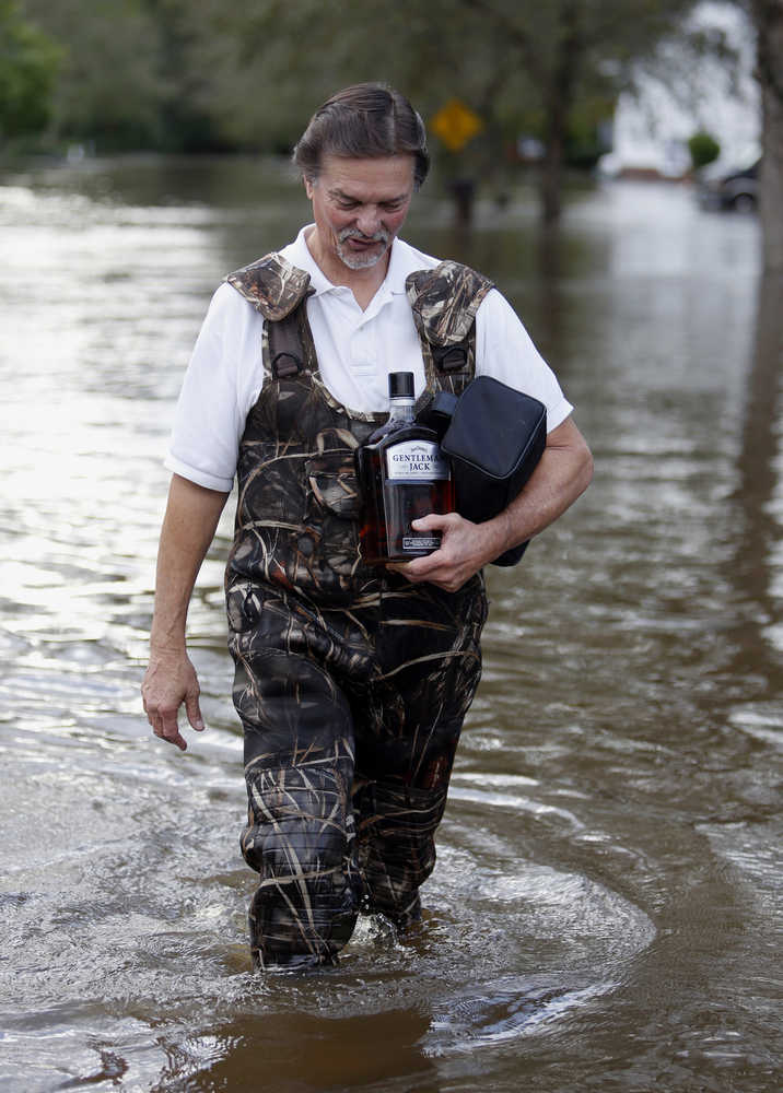 Rick Hoffman evacuates from his house, after making previous trips for personal items, in the Ashborough subdivision near Summerville, S.C., after many of their neighbors left Monday, Oct. 5, 2015. South Carolina is still struggling with flood waters due to a slow moving storm system. (AP Photo/Mic Smith)