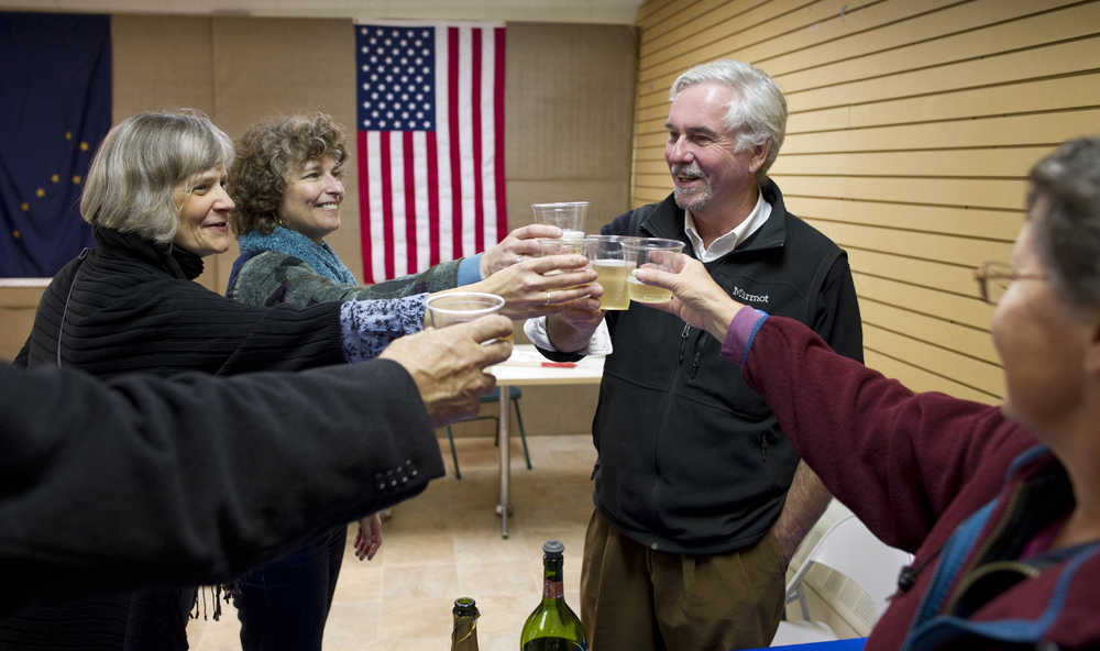 Greg Fisk gets help toasting his win for mayor of Juneau over Merrill Sanford by Patty Ware, left, Patricia Hull and Janet Kussart, right, at his Seward Street campaign headquarters Tuesday evening.