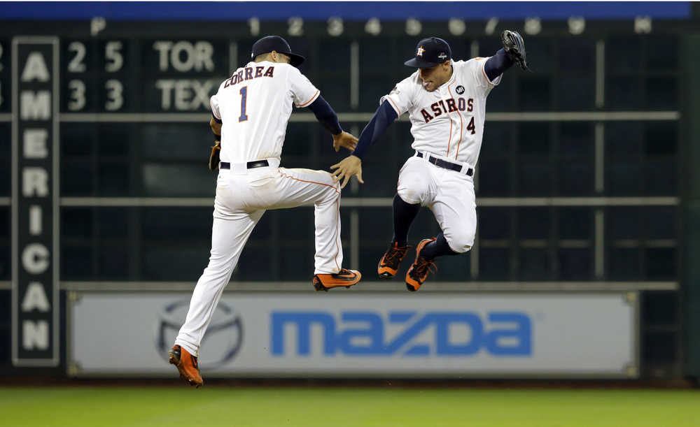 Houston Astros' Carlos Correa (1) and George Springer (4) celebrate after beating the Kansas City Royals 4-2 in Game 3 of baseball's American League Division Series Sunday, Oct. 11, 2015, in Houston. (AP Photo/Pat Sullivan)