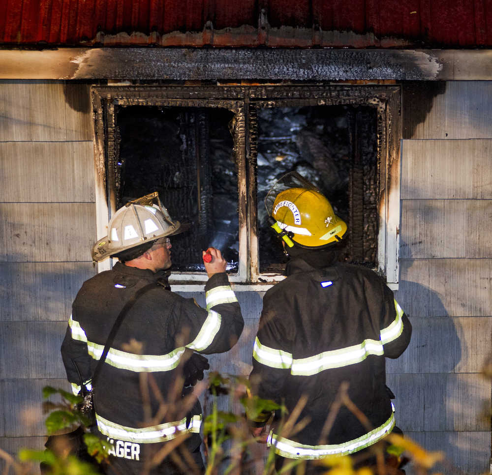 Capital City Fire Rescue Fire Marshal Dan Jager, left, speaks with a firefighter after a fire at a residence at 17625 Lena Loop Road Sunday night. No was home at the time of the fire and there were no injuries. The structure was declared a total loss.