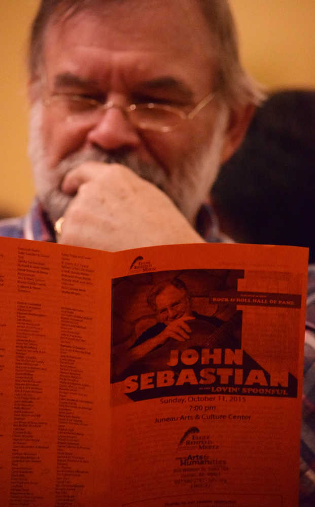 Virgil Fredenberg examines a program before a performance by singer-songwriter guitarist John Sebastian on Sunday, Oct. 11, at the Juneau Arts & Culture Center.