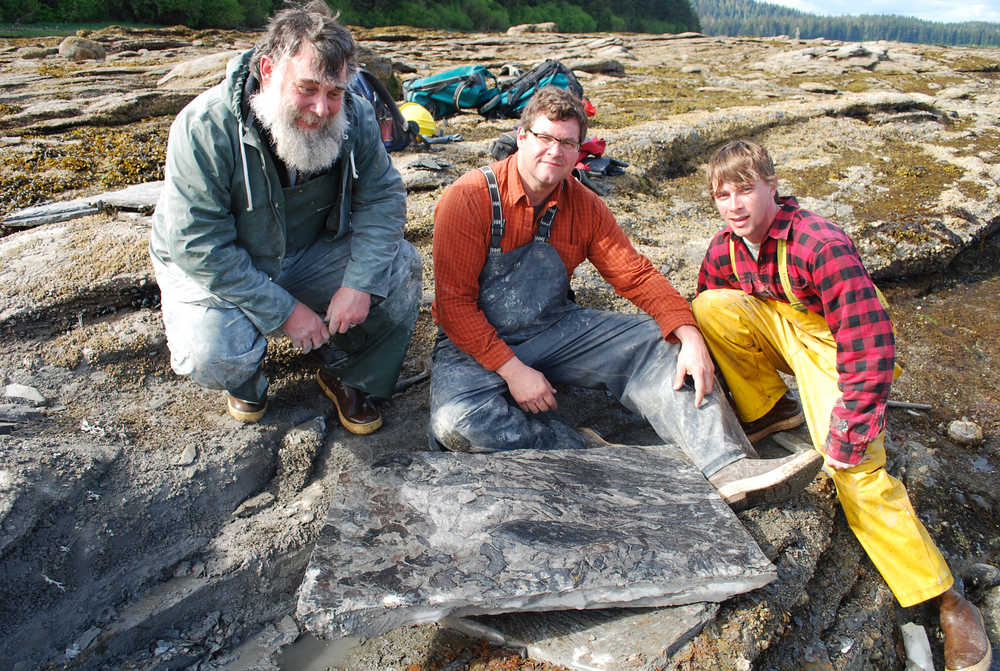 From left to right, USFS Forest Geologist Jim Baichtal, Smithsonian Museum of Natural History Director and paleontologist Kirk Johnson, and geoarchaelogist Ian Putnam pose with a rock slab full of 50 million-year-old fossils.