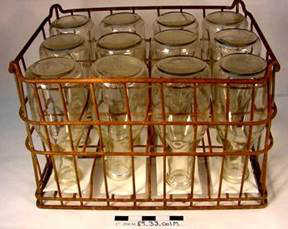 Milk Bottles and Crate, used at the Peterson Dairy, JDCM 89.33.00. Selected for Ordinary Things/Extraordinary Tales by Emily Wall.