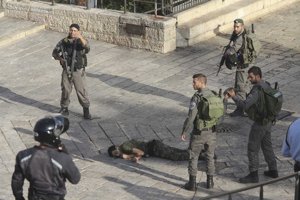 Israeli police stand around a Palestinian shot after he allegedly tried to stab a person at Damascus Gate of the Jerusalem's Old City on Wednesday.