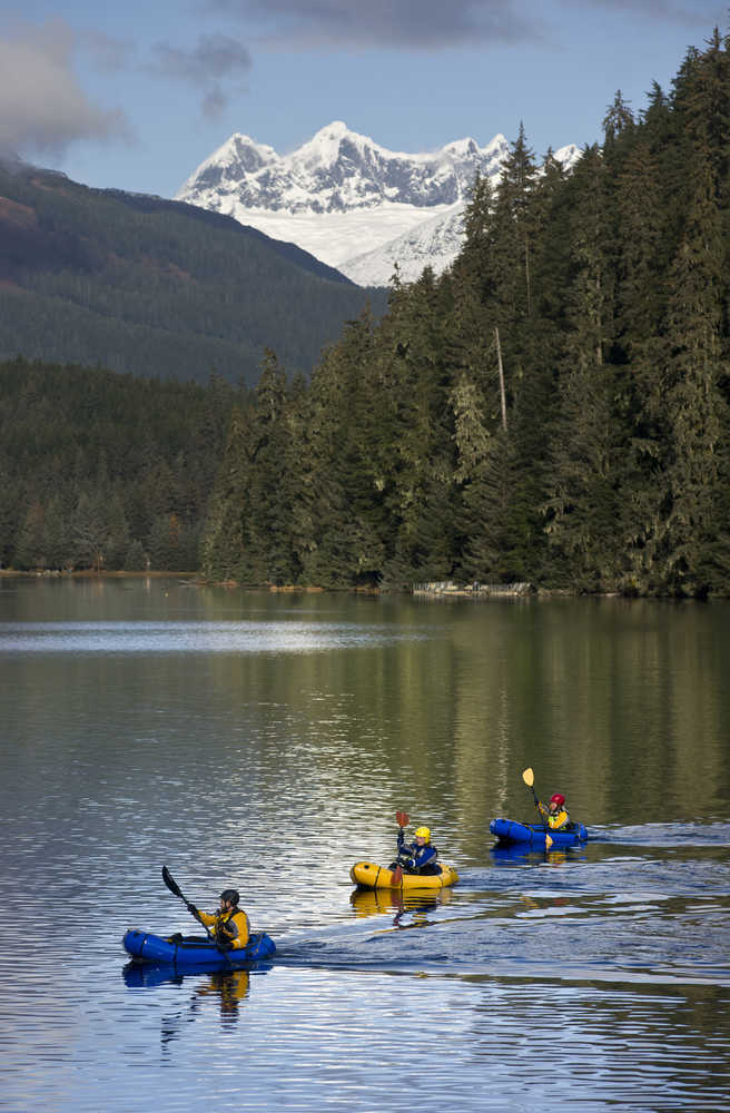 University of Alaska Southeast instructor Forest Wagner, left, leads Casey Burkert, center, and Makaila Olson across Auke Lake in pack rafts during his Outdoor Leadership Class on Wednesday.