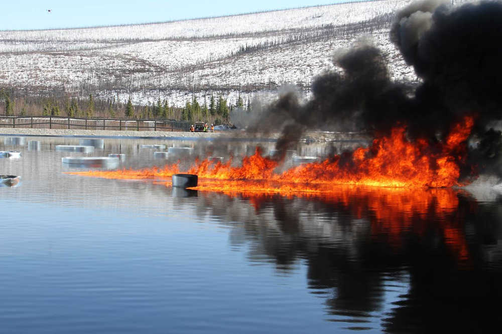 Oil burns on a manmade water basin at Poker Flat Research Range in April 2015.