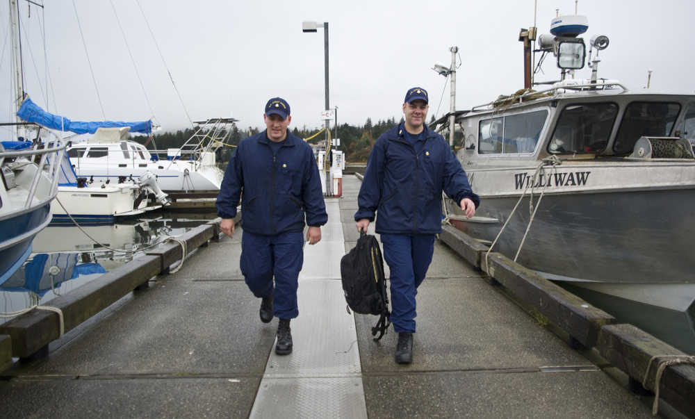 U.S. Coast Guard Petty Officer Second Class Chris Houverner, left, and Petty Officer First Class Ben Stixrud walk the dock at the Don Statter Memorial Boat Harbor in Auke Bay after making a boat safety exam on Friday.
