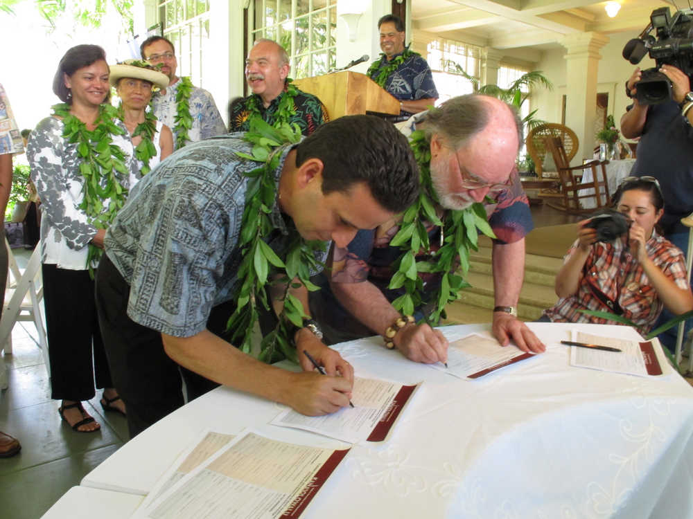 In this July 20, 2012  photo, Hawaii Gov. Neil Abercrombie, right, and Lt. Gov. Brian Schatz sign a petition supporting Native Hawaiian sovereignty in Honolulu.