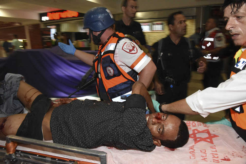In this Sunday photo, Mulu Habtom Zerhoma, a wounded Eritrean, is evacuated from the scene of an attack in Beersheba, Israel.