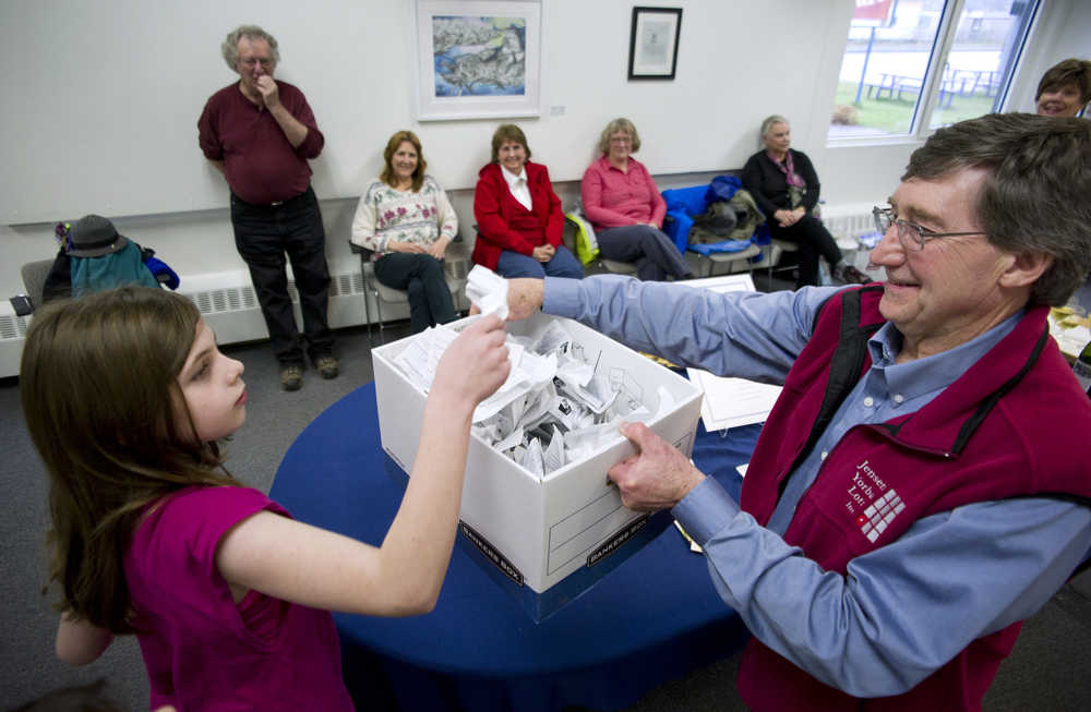 Madeline Germain, 10, helps Wayne Jensen draw a winning name during the Seward Statue raffle drawing at the Juneau Arts & Culture Center on Monday. The winners were Dennis Watson and Cindy Brady. Both won two tickets each to anywhere Alaska Airlines flies. About 150 people paid $100 per ticket to help pay to erect a life-size statue of William Henry Seward at the Dimond Courthouse Plaza.